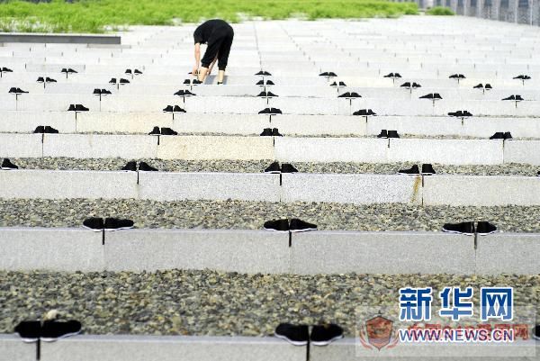 8月14日，一名青年将布鞋整齐地摆放在广场上。 新华社发